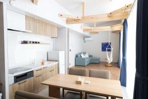 a kitchen and living room with a wooden table and a dining room at ウミチカ in Minamiboso