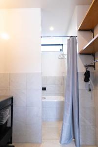 a bathroom with a shower and a shower curtain at ウミチカ in Minamiboso +43 photos