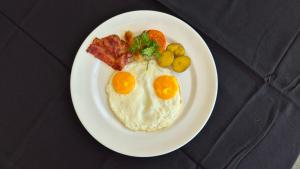 a plate of breakfast food with eggs and bacon at The Tamarin Villas in Nusa Penida