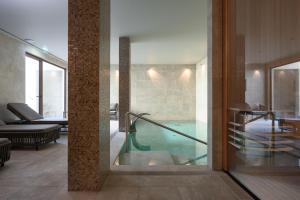 a pool in the middle of a room with a glass door at INNSiDE by Meliá Braga Centro in Braga