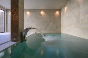 a swimming pool with a water fountain in a room at INNSiDE by Meliá Braga Centro in Braga