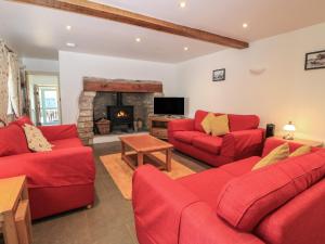 a living room with red couches and a fireplace at Dale Barton in Wells