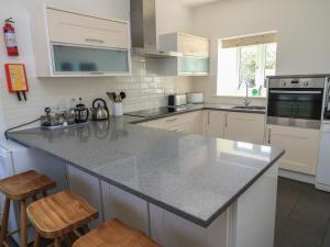 a kitchen with white cabinets and a granite counter top at Dale Barton in Wells