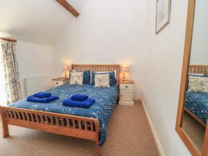 a bedroom with a bed with blue sheets and a mirror at Dale Barton in Wells