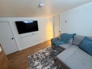 a living room with a couch and a flat screen tv at La Pergola-1 in Quebec City