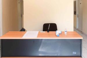 a desk in an office with a bottle of water on it at RedDoorz @ Pavilion Residence Cikarang in Jakarta
