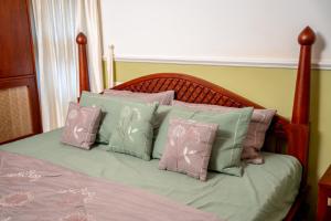 a bed with a bunch of pillows on it at Illam By Santhi in Varkala