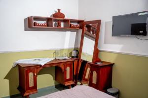 a room with a bed and a desk with a mirror at Illam By Santhi in Varkala