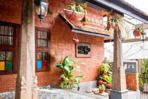 a building with potted plants on the side of it at Illam By Santhi in Varkala