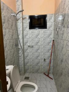 a bathroom with a toilet and a shower stall at Chambre avec salle d eau privée in Mbour