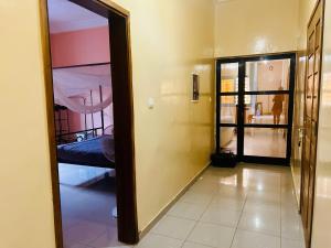 a hallway with a mirror and a bed in a room at Chambre avec salle d eau privée in Mbour