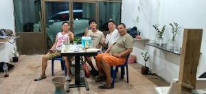 a group of people sitting around a table at Urban Nest Hostel in Bangkok