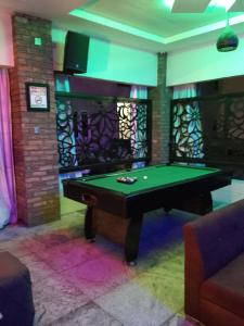 a ping pong table in a room with a pool table at Cogent Apartments and Hotel in Uyo