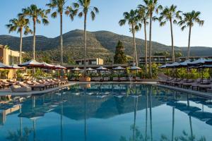 a hotel pool with chairs and palm trees at Hotel Blue Sea Beach, Affiliated by Meliá in Stalís