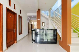 a hallway with stairs and a glass elevator at RedDoorz @ Jalan Danau Limboto in Malang