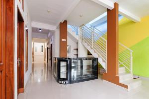 a hallway with stairs and a television in a house at RedDoorz @ Jalan Danau Limboto in Malang