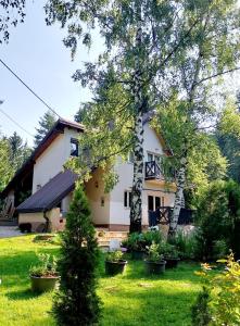 a white house with trees in the yard at Villa Perle de la Montagne in Pale