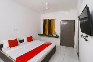 a bedroom with a bed and a flat screen tv at Hotel O Sky Garden in Ludhiana