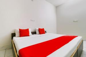 a red and white bed with red pillows on it at Hotel O Sky Garden in Ludhiana +26 photos