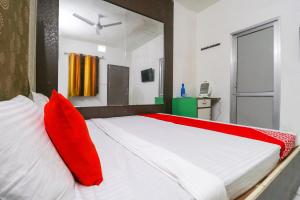 a bedroom with a large bed with red pillows at Hotel O Sky Garden in Ludhiana