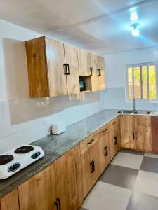 a kitchen with wooden cabinets and a stove in it at Noah Bed&Breakfast 3 Private Room NEWHOME Quiet Place to Stay 14 Minutes to PPS Airport in Puerto Princesa City