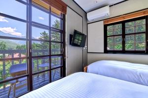 a bedroom with two beds and a window with a view at Fujisan Lodge En in Fujikawaguchiko +109 photos