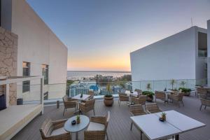 a patio with tables and chairs and a view of the ocean at Meliá Maputo Sky in Maputo