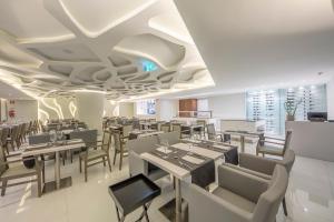 a restaurant with tables and chairs in a room at Meliá Maputo Sky in Maputo +28 photos