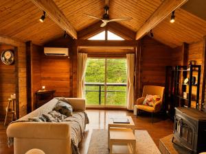 ein Wohnzimmer mit Sofa und großem Fenster in der Unterkunft RENEST in Kōbe