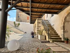 a staircase leading up to a building with a wooden ceiling at Maison éla in Bessas