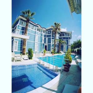 帕莫卡萊的住宿－梅爾羅斯棉花堡美景套房酒店，一座带游泳池和棕榈树的大型蓝色建筑