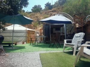 a group of chairs and umbrellas in a yard at Eldorado Yurt in Algarrobo