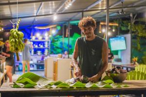 a man standing at a table preparing food at Kalunay Hostel - Breakfast included in Puerto Viejo
