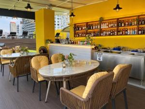 a restaurant with two tables and chairs and a bar at Miloft Sathorn Hotel in Bangkok