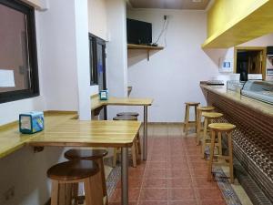 a kitchen with wooden tables and stools in a restaurant at Hostal San Marcos II in Guadalajara