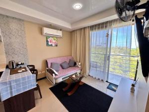 a living room with a chair and a window at Cozy apartment with a sea view in Ban Bo Sai Klang