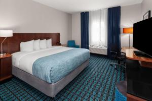 a hotel room with a large bed and a desk at Wingate by Wyndham Oshkosh in Oshkosh +36 photos