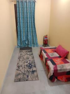 a room with two beds and a curtain and a window at Two BHK and Four BHK Fully Furnished Flats for 1 to 13 guests - Near Charminar and Salar Jung Museum in Hyderabad