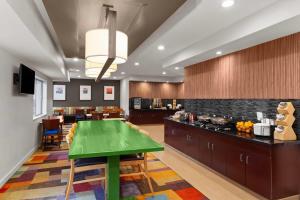 a kitchen with a green table in a room at Wingate by Wyndham Oshkosh in Oshkosh