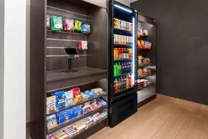 a store aisle with a refrigerator filled with food at Wingate by Wyndham Oshkosh in Oshkosh