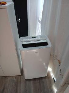 a white trash can sitting on the floor next to a door at Apartamento Carreira Sada in Sada