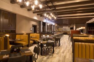 a restaurant with tables and chairs and a bar at Dolce by Wyndham Parsippany in Parsippany