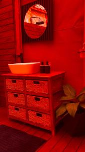 a bathroom with a sink and a red wall at Terracotta River Hideaway in Maun