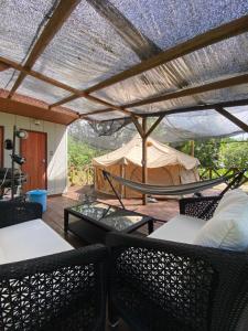 a patio with a hammock and a tent at Muribushi-PLUS Gramping TENT in Motobu