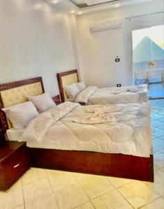 two beds sitting next to each other in a room at malak pyrameds rofe top in Cairo