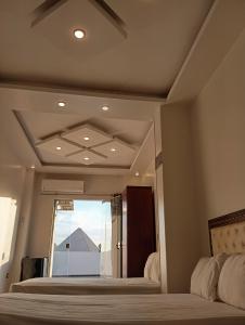 a bedroom with two beds and a window at malak pyrameds rofe top in Cairo +16 photos