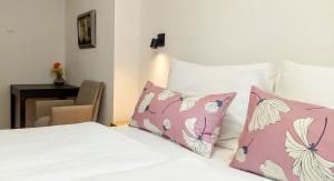 a bed with pink and white pillows and a table at Ferienwohnung Sofka in Sekull