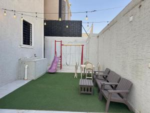 a patio with a playground with benches and a swing at دور فخم كامل 6 غرف بحوش خاص ومدخل سيارة in Taif