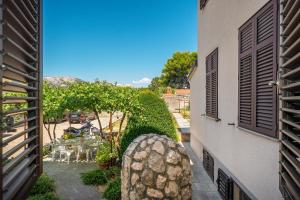 a balcony of a building with a table and chairs at Apartment & Rooms Three Angels in Baška