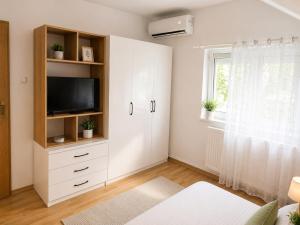 a living room with a tv and a white cabinet at Vila Ioana in Ştefăneşti